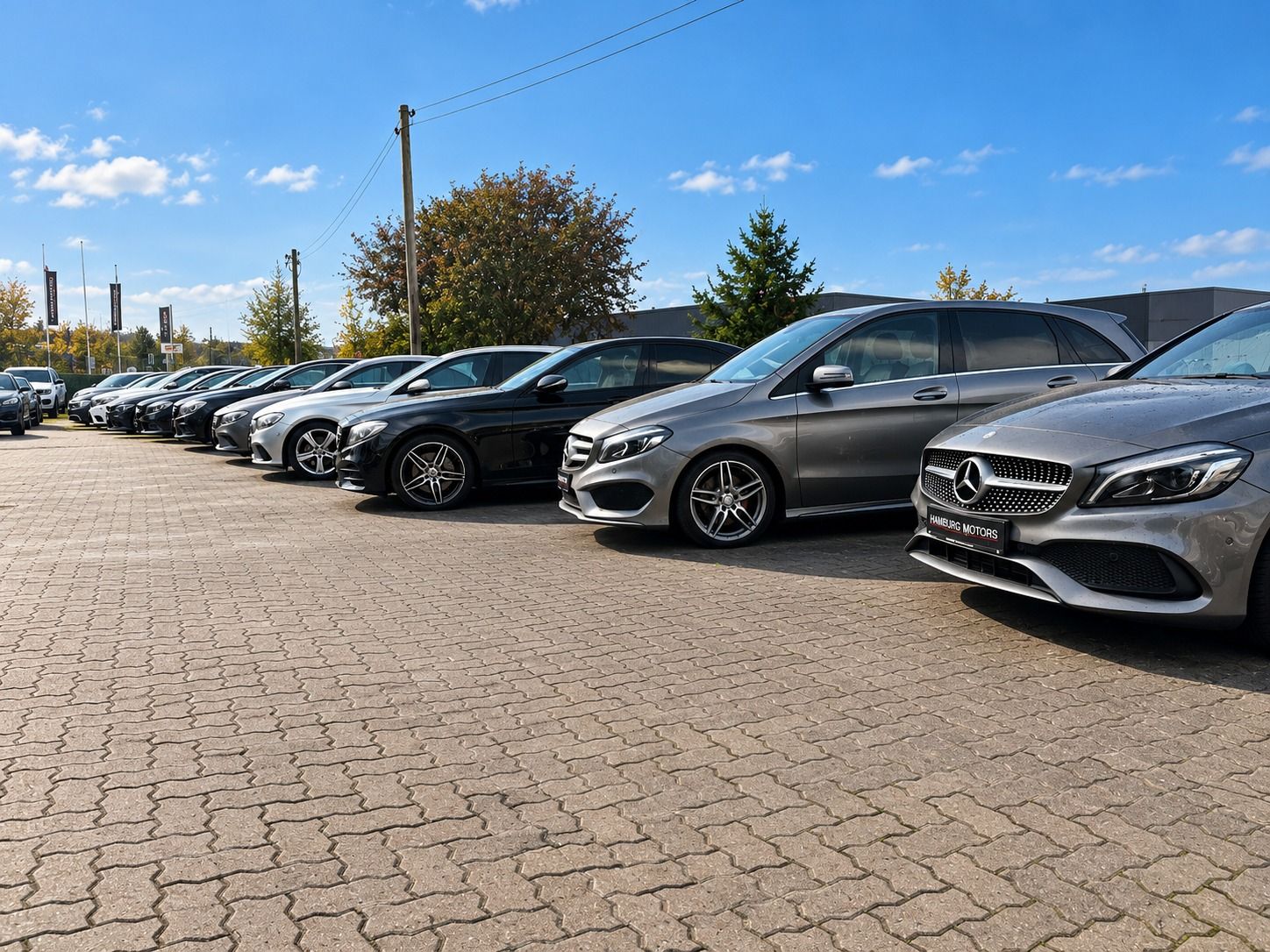 Mercedes-Benz-Gebrauchtwagen mit Hamburg-Motors-Kennzeichenhalter in einer Reihe auf dem Hof